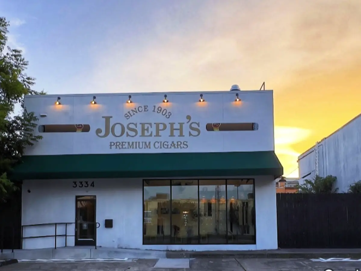 Joseph's Premium Cigars storefront at dusk with custom exterior steel handrail
